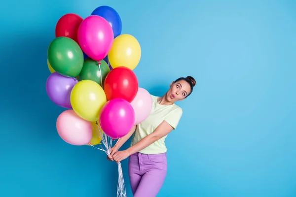 Φωτογραφία πορτρέτο του αστείο κορίτσι κρατώντας σωρός από πολύχρωμα μπαλόνια αέρα κοιτάζοντας με συγκλονισμένο πρόσωπο απομονώνονται σε ζωντανό φόντο μπλε χρώμα — Φωτογραφία Αρχείου
