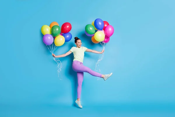 Longitud completa tamaño del cuerpo foto de la chica divertida saltando mantener globos de aire bailando riendo aislado sobre fondo de color azul brillante —  Fotos de Stock