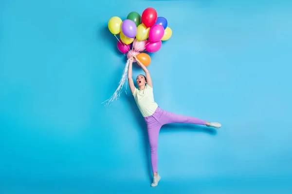 Longitud completa tamaño del cuerpo foto de la muchacha que guarda la pila de globos coloridos aire asombrado viento tiempo aislado sobre fondo de color azul vivo — Foto de Stock