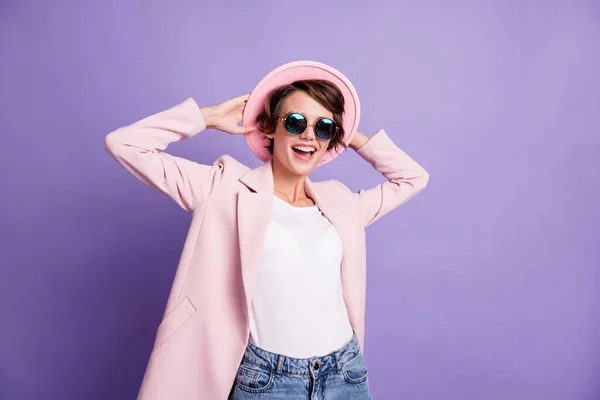 Fénykép aranyos pozitív Bob frizura fiatal hölgy viselni sapka kabát kezét a fejét elszigetelt lila pasztell szín háttér — Stock Fotó