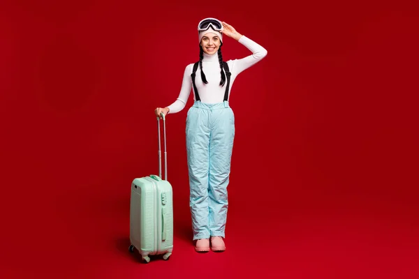 Foto em tamanho completo de jovem atraente menina positiva feliz com caudas sorrindo deixando para férias isoladas em fundo de cor vermelha — Fotografia de Stock