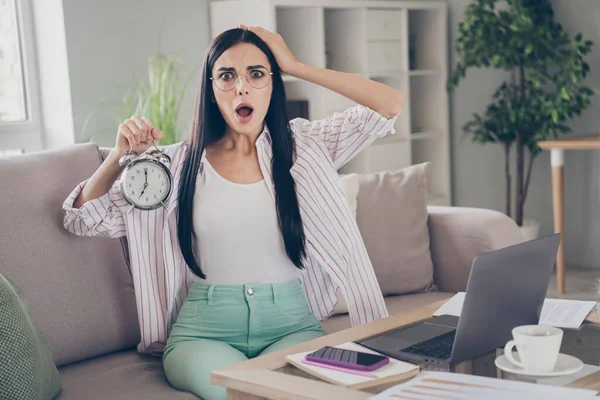 Portrét fotografie šokované nervózní brunetky žena vedení budíku zírá ohromeně s otevřenými ústy pracovní z domova — Stock fotografie