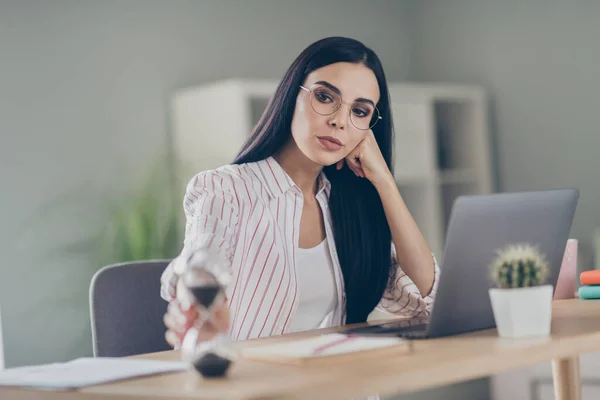 Foto de la señora contable inteligente sentada mesa con gafas contando los últimos minutos fin de día de trabajo espacio interior oficina — Foto de Stock