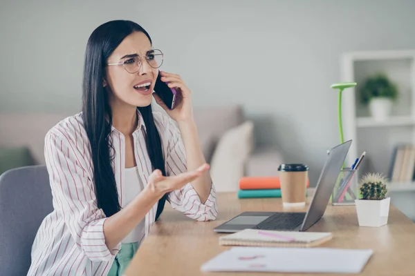 Foto de perfil de la furiosa mujer de negocios indignada sentada mesa hablando buscando copyspace espacio vacío interior taller — Foto de Stock