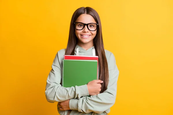 Foto da pessoa da escola sorrir braços segurar livro usar óculos isolados no fundo de cor amarelo brilhante — Fotografia de Stock