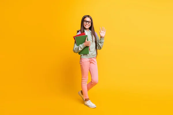 Retrato de cuerpo completo de estudiante llevar mochila onda brazo elegante sudadera con capucha aislado sobre fondo de color amarillo —  Fotos de Stock