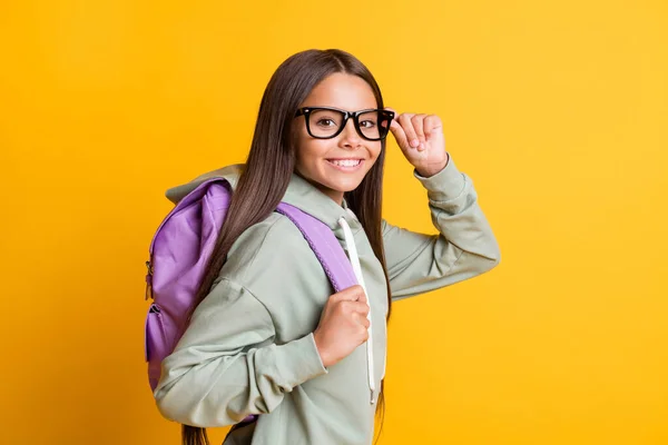 Profiel portret van school persoon arm aanraking brillen dragen rugzak geïsoleerd op gele kleur achtergrond — Stockfoto