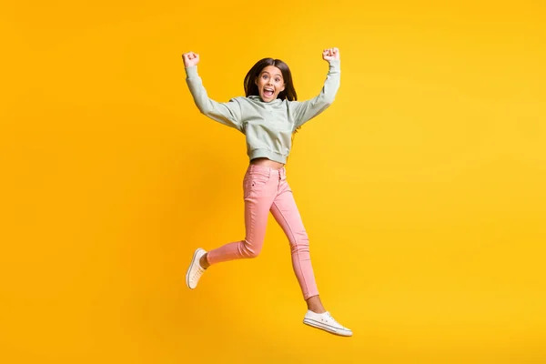 Retrato de tamaño completo de la persona de la escuela saltar brazos de aire puño hacia arriba ganó con estilo aislado en el fondo de color amarillo —  Fotos de Stock