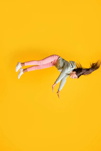 Kızların hayal gücünün dikey profil portresi. Canlı sarı arka planda izole edilmiş uçuş tarzı kıyafet. — Stok fotoğraf