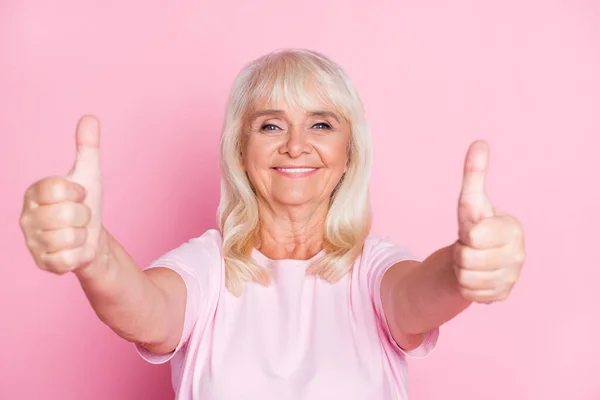 Zdjęcie portret szczęśliwej babci demonstrujące jak kciuk-up znaków z obu rąk uśmiechnięty izolowany na pastelowym różowym tle koloru — Zdjęcie stockowe