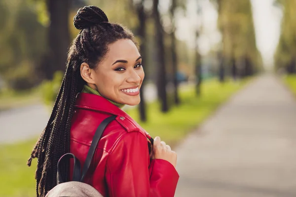 Foto van jonge vrolijke aantrekkelijke afro vrouw blij positieve glimlach genieten herfst wandeling park weekend kijk terug — Stockfoto