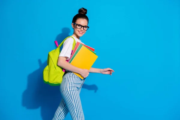 Perfil lado de la foto de la chica positiva mantenga los libros de copia ir a pie clase lecturas biblioteca copyspace use ropa de buen aspecto aislado sobre brillante brillo color fondo — Foto de Stock