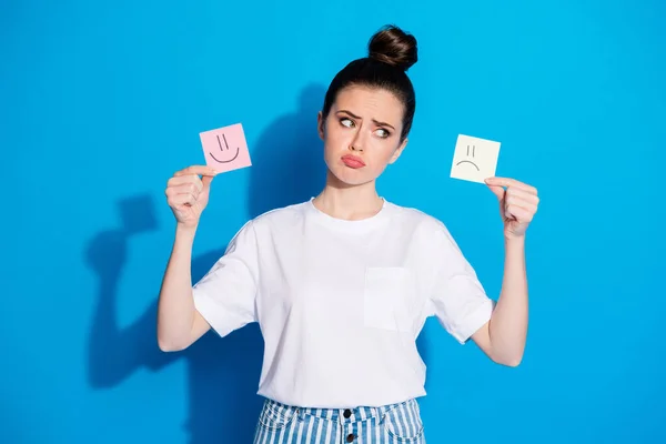 Retrato de ella ella atractiva atractiva bastante encantador descontento sombrío sombrío chica de mal humor sosteniendo en las manos dos tarjetas de emociones diferentes aisladas en brillante seno vivo vibrante fondo de color azul — Foto de Stock