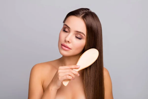 Retrato de encantadora chica atractiva cepillo peine su fuerte bienestar brillante natural corte de pelo largo disfrutar de cuidado corporal cuidado de la piel procedimiento cerrar los ojos aislados sobre fondo de color gris —  Fotos de Stock