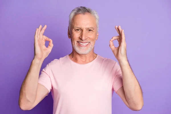 Φωτογραφία του συνταξιούχου γέρου σηκώστε δύο χέρια δείχνουν okey λευκό χαμογελαστό φορούν ροζ t-shirt απομονωμένο βιολετί φόντο χρώμα — Φωτογραφία Αρχείου
