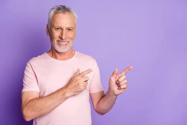 引退したおじいちゃんの写真は、指が空のスペースを示すピンクのTシャツ孤立紫色の背景を身に着けている — ストック写真
