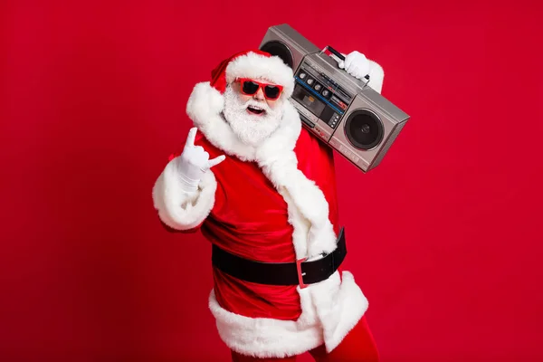 Full body size photo of retired old man grey beard hold boombox show horns make youngsters hard loud noise wear santa costume sunglass headwear x-mas isolado red color background — Fotografia de Stock