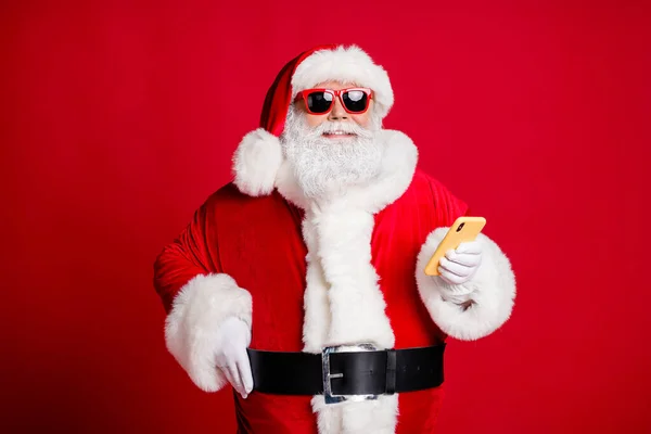 Portret van zijn hij mooie knappe aantrekkelijke vrolijke bebaarde Kerstman met behulp van apparaat 5g bloggen commentaar media multimedia felicitatie geïsoleerde heldere levendige glans levendige rode kleur achtergrond — Stockfoto