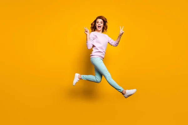 Foto de corpo inteiro da mulher animada louca alegre desfrutar de férias de primavera salto fazer v-sinal grito alegrar usar roupas de estilo casual isolado sobre fundo de cor amarela — Fotografia de Stock