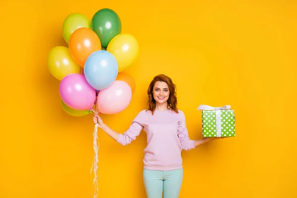 Porträt einer fröhlichen Frau halten Heliumballons grün gepunktete Geschenkbox sie für Freunde Jahrestag vorbereiten tragen lässigen Stil Pullover isoliert über Glanz Farbe Hintergrund — Stockfoto