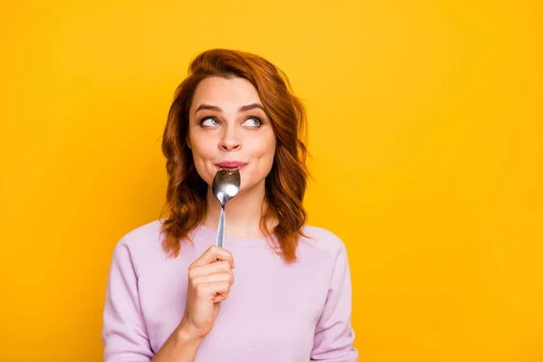 Retrato de encantador bonito inspirado mulher positiva segurar lamber colher pensar pensamentos sobre o café da manhã gostoso olhar copyspace desgaste rosa jumper isolado sobre fundo de cor amarela — Fotografia de Stock