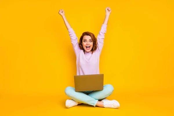 Full length photo of delighted crazy woman sit floor legs crossed folded work laptop win loteria podnieść pięści krzyczeć tak nosić różowe spodnie morski tenisówki izolowane na jasnym tle koloru — Zdjęcie stockowe