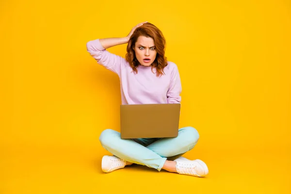 Plná délka fotografie ohromen frustrovaný žena sedět nohy přes pracovní počítač číst pracovní dokument šokovaný dotek účes křičet omg nosit stylové oblečení izolované žluté barvy pozadí — Stock fotografie