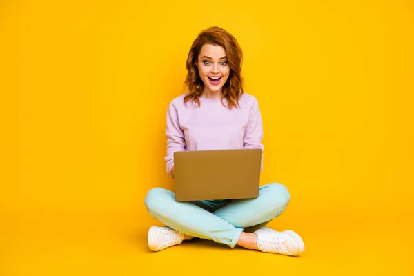 Full size photo astonished girl sit floor legs folded cross work computer read information watch video call communicate with friends wear good look pullover isolated shine color background — Zdjęcie stockowe