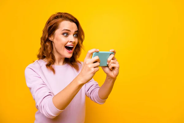 Ritratto di positivo allegro divertente ragazza uso smartphone giocare video giochi di corse godere di gioire usura buon look maglione isolato su sfondo di colore brillante — Foto Stock