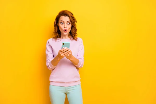 面白い狂気の言葉の女性の写真口を開けて電話を保持正のコメントを読んで自分の人気のブログを着用ピンクのプルオーバー緑のパンツ孤立黄色の色の背景 — ストック写真