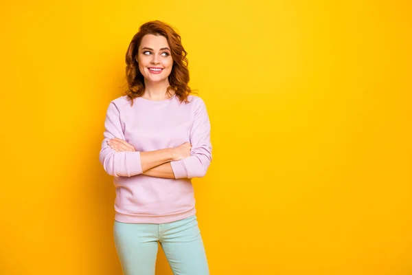 Photo of beautiful curly lady hands crossed business company boss friendly toothy smiling look interested empty space wear pink pullover green trousers isolated yellow color background — Stock Photo, Image