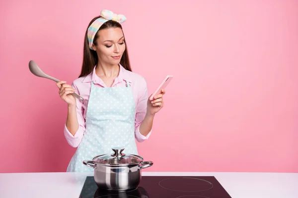 Retrato de ella ella agradable atractiva bastante centrado ama de casa blogger cocina comida casera almuerzo gourmet receta de navegación ingrediente aprendizaje aislado en rosa pastel color fondo —  Fotos de Stock