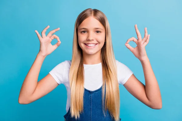 Närbild foto av söt optimistisk tonåring blond långt hår flicka visa okey tecken bära vit t-shirt isolerad över pastell blå färg bakgrund — Stockfoto