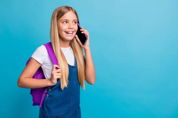 写真のかっこいい十代の女の子見て空のスペーストーク電話ウェアバッグデニムドレス孤立した上パステルブルー色の背景 — ストック写真