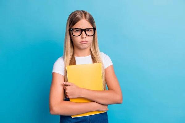 Foto von traurigen Schülerin Mädchen wollen nicht tun Hausaufgaben tragen Brille halten Buch isoliert auf pastellblauem Hintergrund — Stockfoto