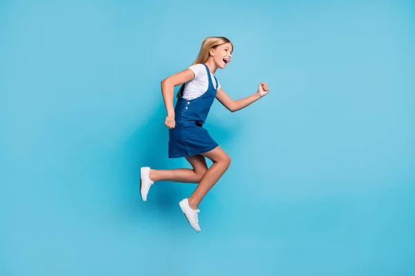 Perfil de tamaño completo foto de alegre chica rubia divertida saltando gritar usar camisetas de vestir zapatillas aisladas sobre fondo de color azul pastel —  Fotos de Stock