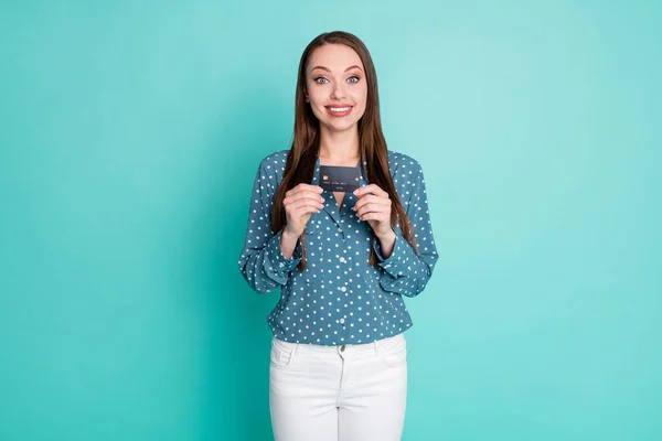 Foto de chica positiva llevar tarjeta de crédito desgaste azul lunares ropa blanca aislada sobre fondo de color verde azulado —  Fotos de Stock