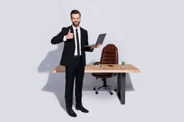 Ganzkörperfoto von gutaussehenden Geschäftsmann halten Notizbuch Hände plaudern Kollegen gute Laune Stand Büro Daumen hoch tragen Blazer Hemd Hose Schuhe Anzug isoliert grauen Hintergrund — Stockfoto