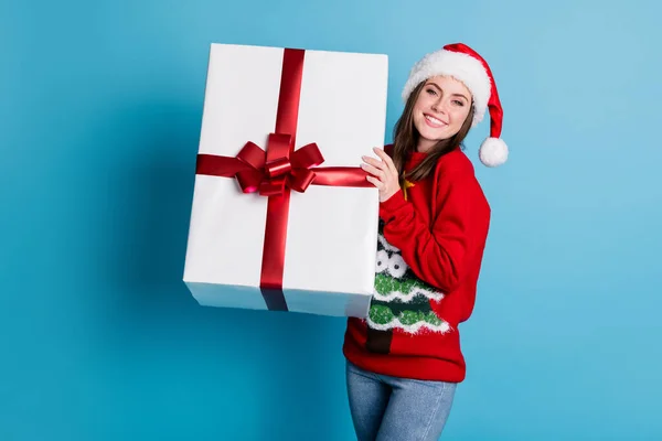 Ritratto foto di sorridere felice ragazza ridente indossa divertente maglione rosso brillante e copricapo mantenendo grande regalo scatola bianca per le vacanze isolato su sfondo di colore blu — Foto Stock