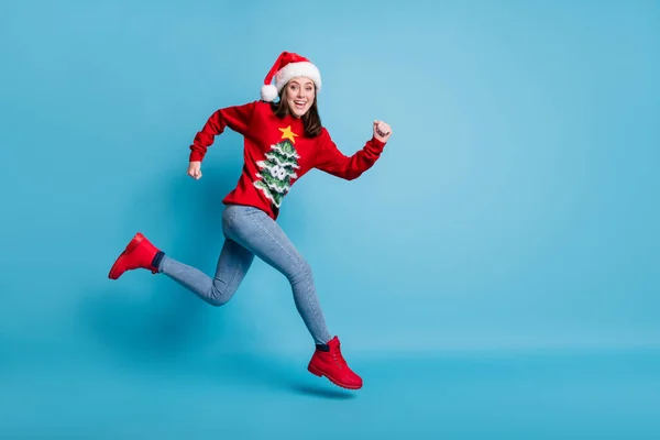 Pleine longueur profil photo de drôle jolie mignonne dame saut courir air usure Santa x-mas casque rouge décoré pullover bottes jeans isolé fond de couleur bleue — Photo