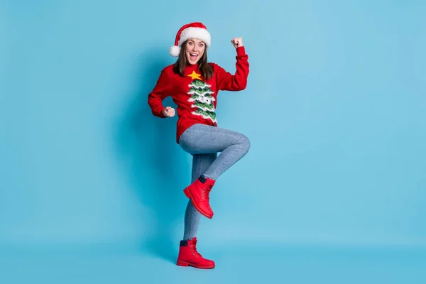 Full body size photo of lovely pretty lady raise hands knee fists excited open mouth wear santa x-mas headwear red ornamented pullover jeans boots isolated blue color background — Fotografia de Stock