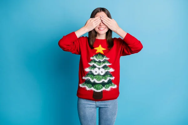 Photo of positive girl in christmas tree decor sweater close cover hands face x-mas wish gift surprise isolated over blue color background — Stock Photo, Image