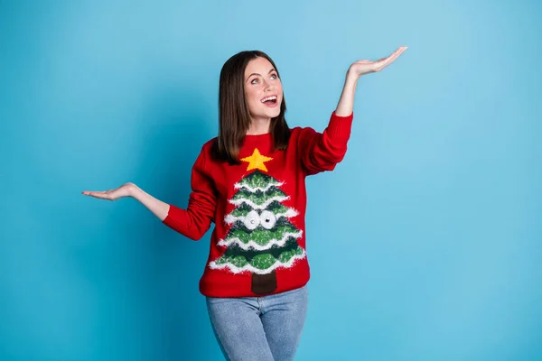 Photo of excited girl in christmas tree sweater pullover hold hand look copyspace x-mas magic isolated over blue pastel color background — Stock Photo, Image