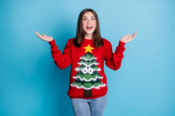 Photo portrait astonished woman catching snow with two hands wearing red sweater tree star googly eyes jeans isolated on pastel light blue colored background — Stock Photo, Image