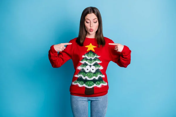 Photo portrait of young brunette girl pointing fingers at herself surprised wearing red pullover with tree googly eyes star isolated on pastel light blue colored background — Stock Photo, Image