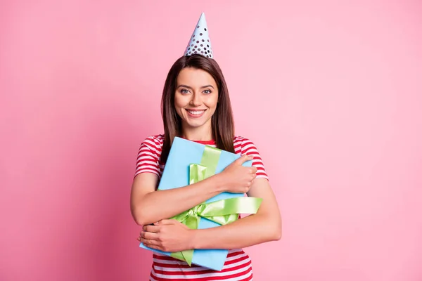 Foto ritratto di felice compleanno ragazza abbracciando regalo avvolto indossa cono festivo isolato su sfondo di colore rosa pastello — Foto Stock