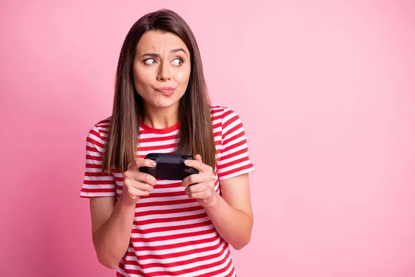 Foto portret van teleurgesteld meisje spelen video game holding controller kijken naar copyspace geïsoleerd op pastel roze kleur achtergrond — Stockfoto