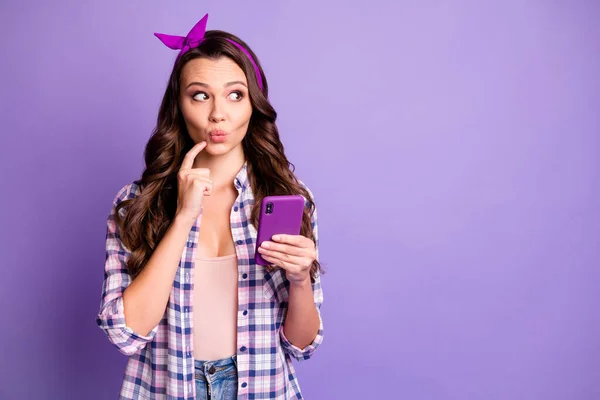 Фотографія роздумів дівчини тримає смартфон виглядає копія простору дотик пальця підборіддя ізольовано на фіолетовому кольоровому фоні — стокове фото