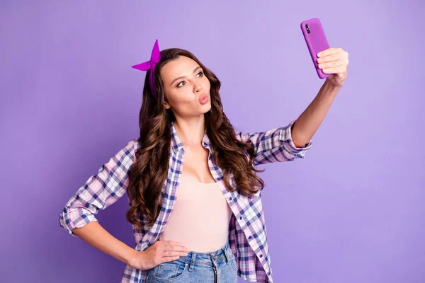 Фото привабливої леді візьміть селфі на смартфон, щоб відправити повітряний поцілунок носити простий одяг ізольований на фіолетовому кольоровому фоні — стокове фото