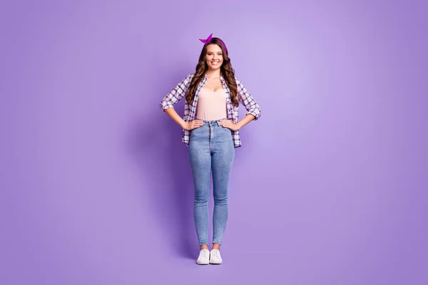 Full length foto di ragazza mani fianchi travi sorridente usura plaid camicia vintage fascia jeans scarpe da ginnastica isolato viola colore sfondo — Foto Stock